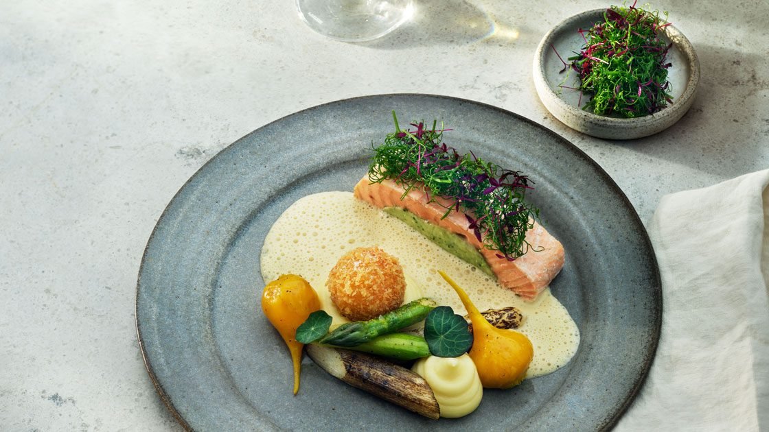 Ugnsbakad örtfärserad rödingfilé med potatispuré med Västerbottensost serveras med grön sparris, vit sotad sparris, gulbetor, en svampfylld krokett och champagnesås